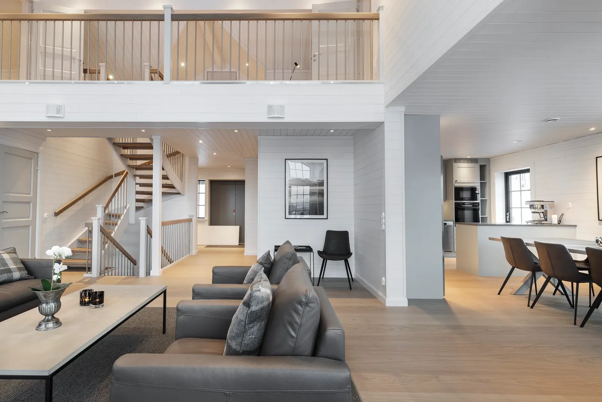 Öppen planlösning med loft, trappa, sittgrupp och matplats.